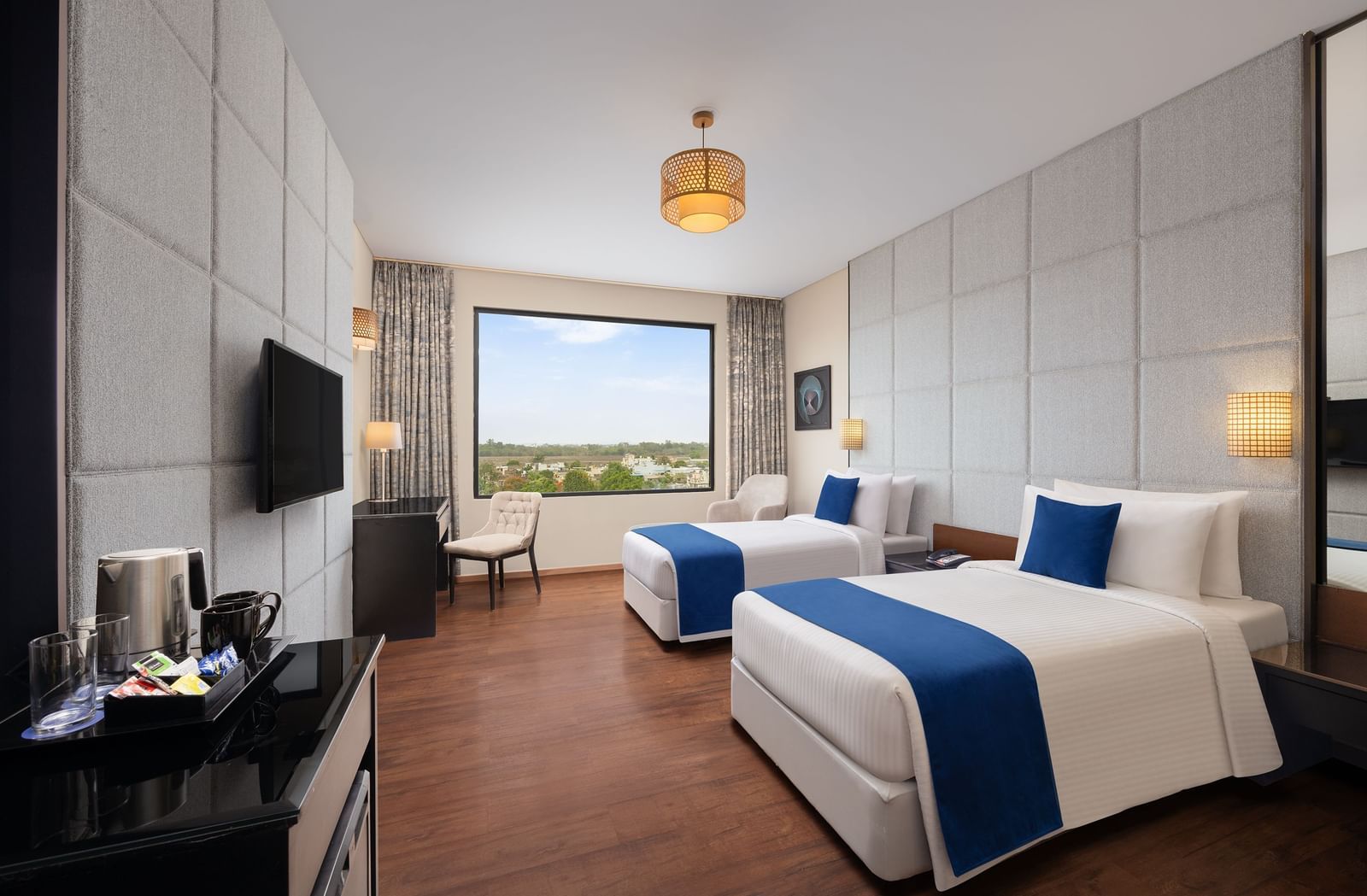 Twin-bed Premium Room with pool view, modern decor, and elegant furnishings at Essentia Luxury Hotel, Indore.