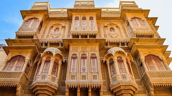 Elaborately carved sandstone building facade with ornate windows and balconies.