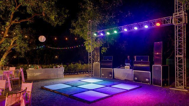 alt-text Festive dance floor with colorful lights and music equipment.