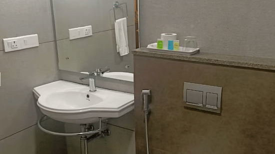 A bathroom is equipped with a sink and a toilet. - Abad Brookside Lakkidi, Wayanad