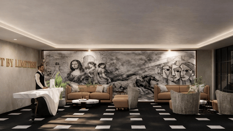 Lounge area of Lime Tree Hotels & Service Apartment Private Limited featuring a black and white mural, checkered flooring, and white sofas arranged around a central table.