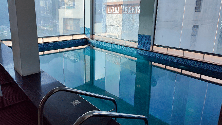 A swimming pool at Regenta Inn DLS with calm waters.