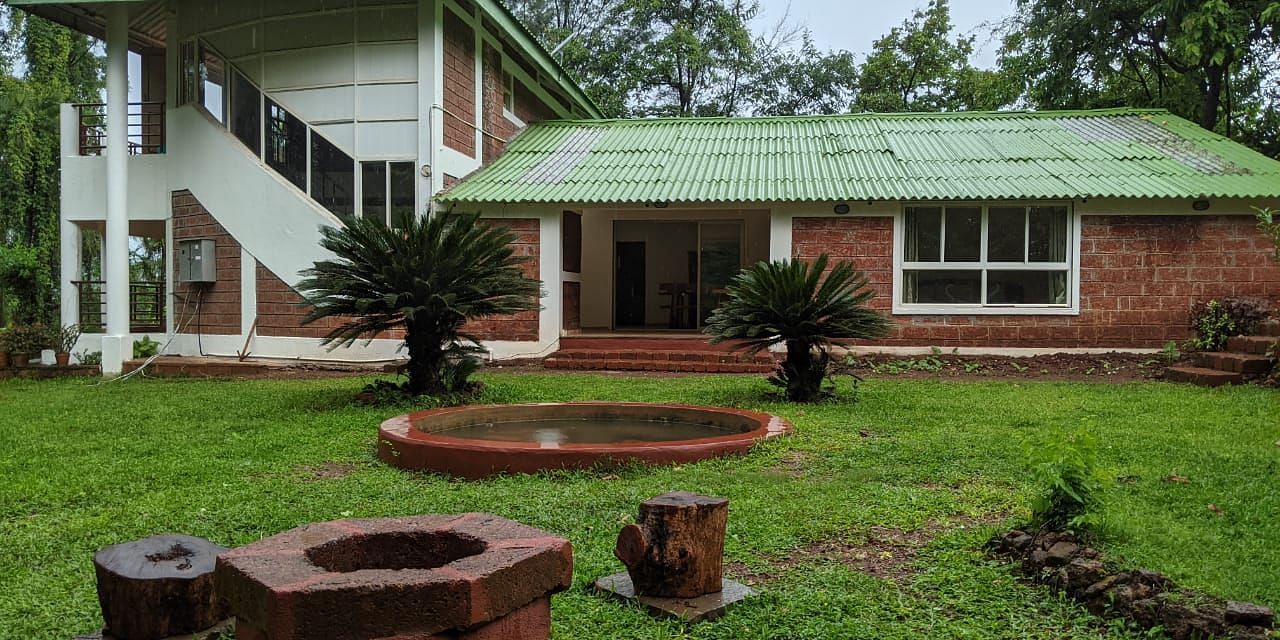 Exterior view of The Conservancy Bungalow with a green roof and a firepit in the lawn.