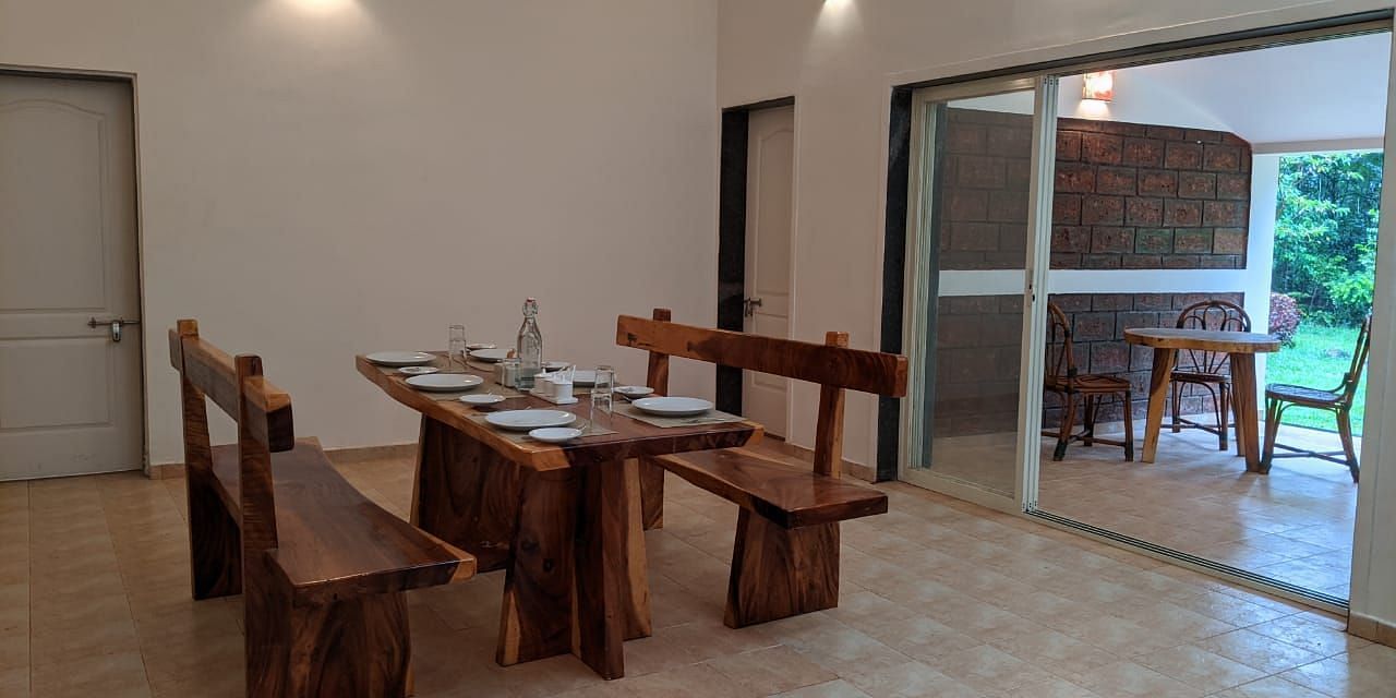 Indoor dining space with rustic wooden furniture and bright lighting at The Conservancy Bungalow.