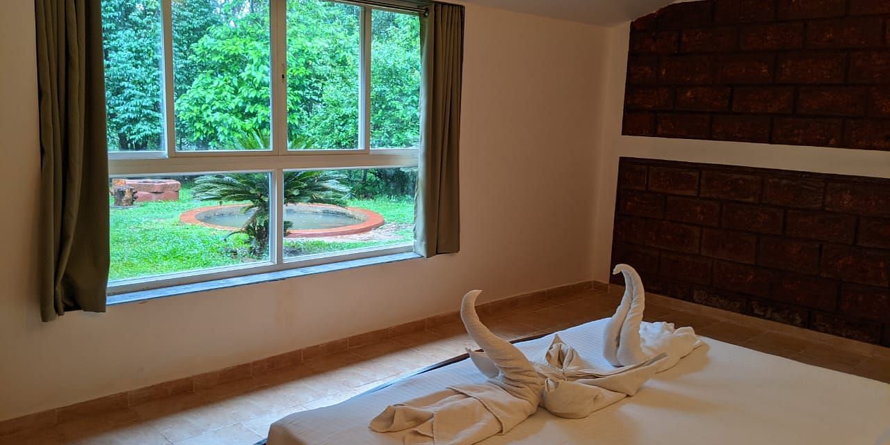  A bedroom with a scenic garden view through a large window at The Conservancy Bungalow.