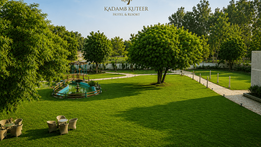 Manicured lawn with a garden pathway and branded property signage at Kadamb Kuteer, Vrindavan.