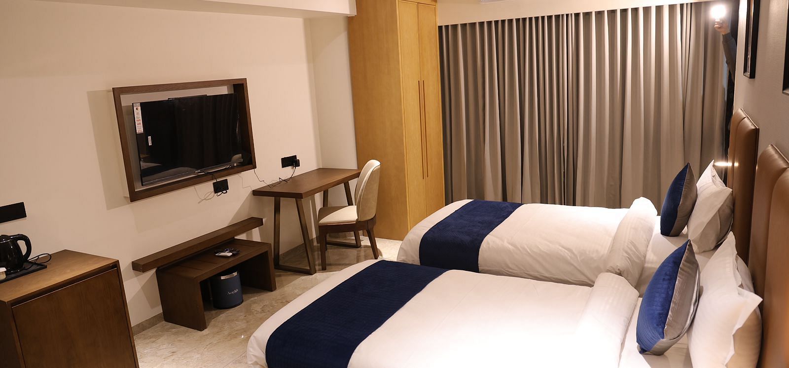 A spacious hotel room at Lords Eco inn Jamnagar Maheshwari Nagar with a large bed television and seating area.