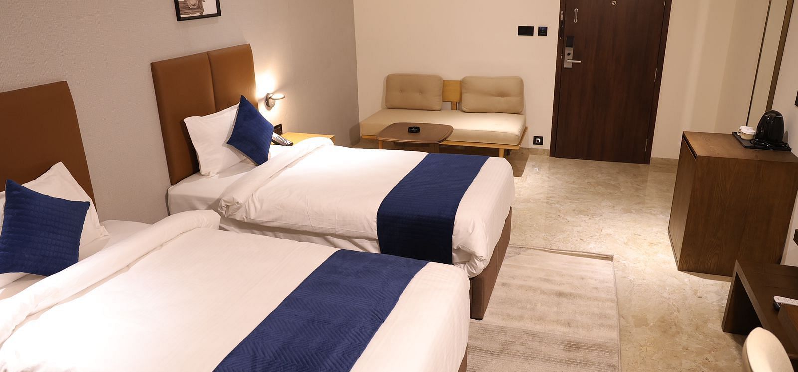 A twin bed room at Lords Eco inn Jamnagar Maheshwari Nagar offering comfortable accommodation and modern design.