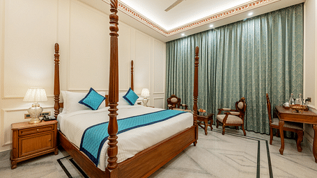 full view image of the room featuring a double bed along with a common seating area at the far end of the room - Brij Castle, Jaipur