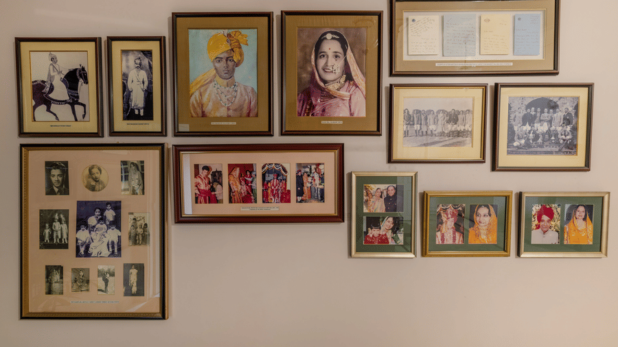 Wall gallery with numerous framed vintage portraits and paintings arranged on a cream wall at Barwara Kotha, Jaipur.