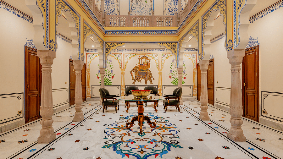 full view image of the ground floor lobby area with colourful tiles on the floor along with detailed floral paintings on the ceiling - Brij Castle, Jaipur