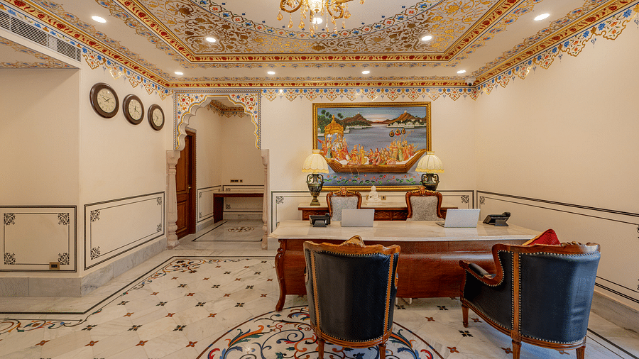 front view image of the reception with a huge desk with a white marble counter and a beautiful painting behind it - Brij Castle, Jaipur