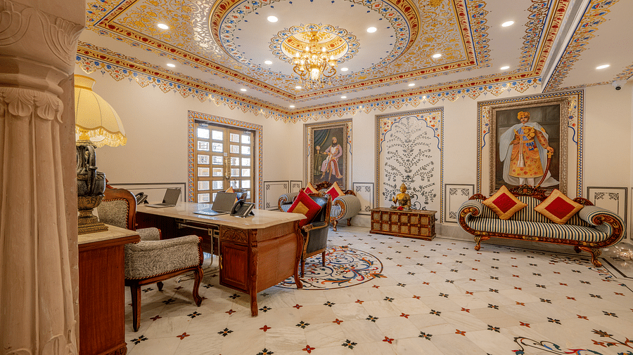 a beautiful reception area with an intricately designed ceiling and a waiting area in the back - Brij Castle, Jaipur