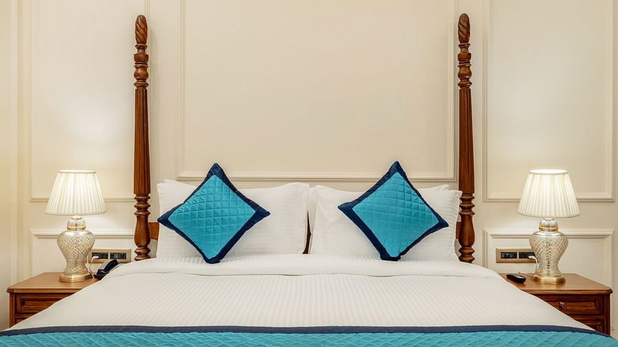a close up image of the king size bed with two bed side lamps on either side of it - Brij Castle, Jaipur