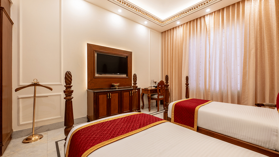 a wall mounted flat television in a bedroom seen over from a twin bed - Brij Castle, Jaipur