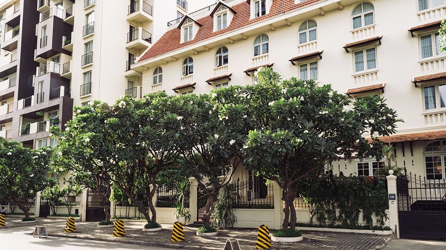 A street view of a multi-storey building with trees lining the road | Central Mansions, Phnom Penh