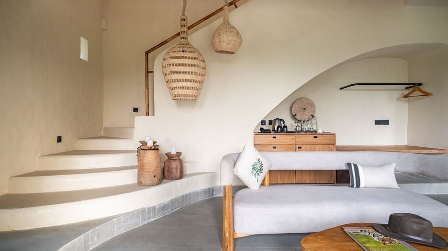 Interior view of a rustic-style living area with hanging woven lights and wooden furniture.