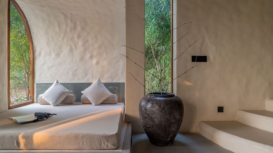 Built-in cushioned seating by a tall arched window with soft natural lighting.