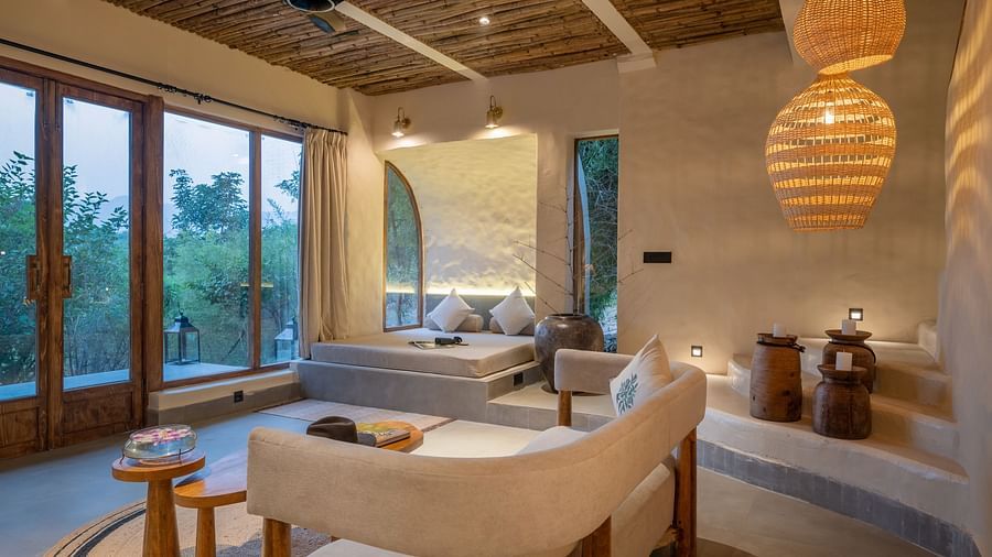 Spacious living room with large windows, woven pendant lights, and earthy decor.
