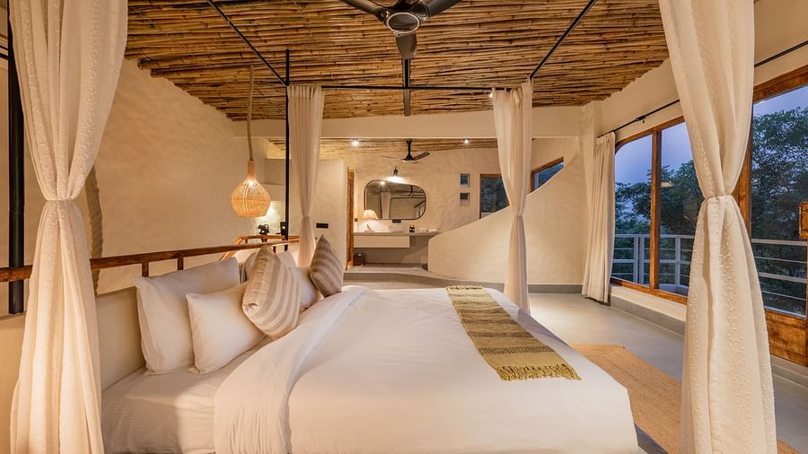 Elegant canopy bed in a spacious room, draped with soft curtains and warm lighting.