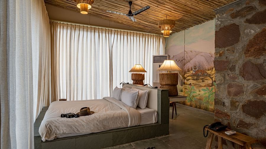 an image of a room with a queen size bed decorative lighting and wall paintings - Utsav Camp Sariska