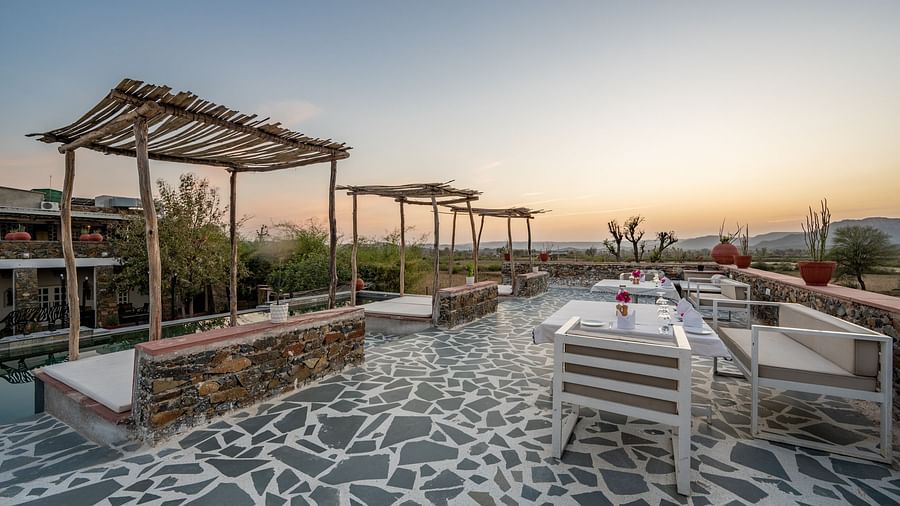 An image of a seating arrangement near the swimming pool in the open - Utsav Camp Sariska