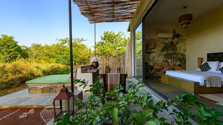 An image of a room with outdoor seating amidst lush greenery - Utsav Camp Sariska