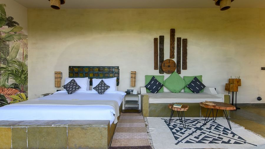 An image of a room with a queen size bed with two decorative chandeliers and other decorative items - Utsav Camp Sariska