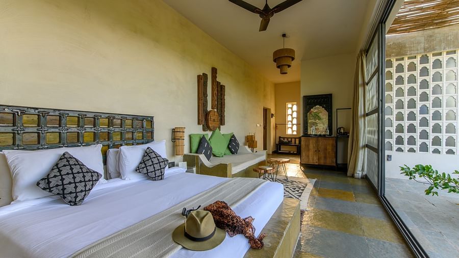 An image of a room with a queen size bed, chandelier, ceiling fan and other decorative items - Utsav Camp Sariska