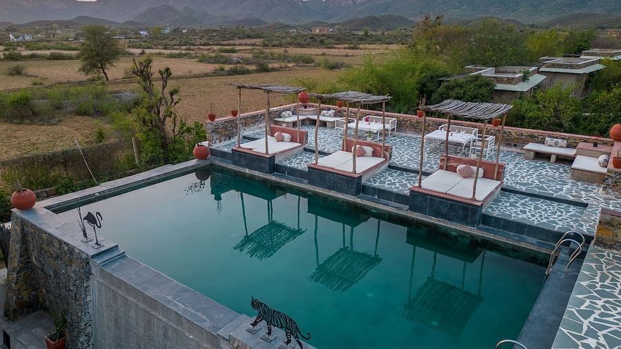 An image of a seating arrangement near the swimming pool in the open - Utsav Camp Sariska