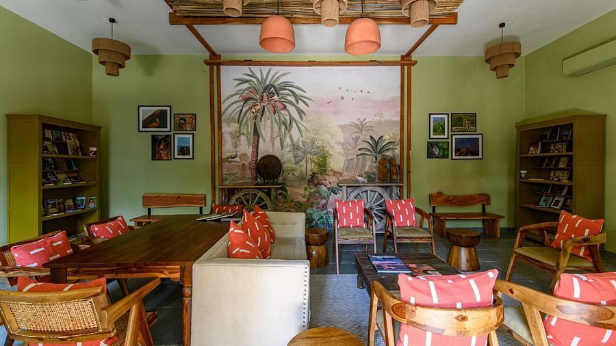 An image of a room with sofa set, center table wall hangings and paintings with minimal decorations - Utsav Camp Sariska
