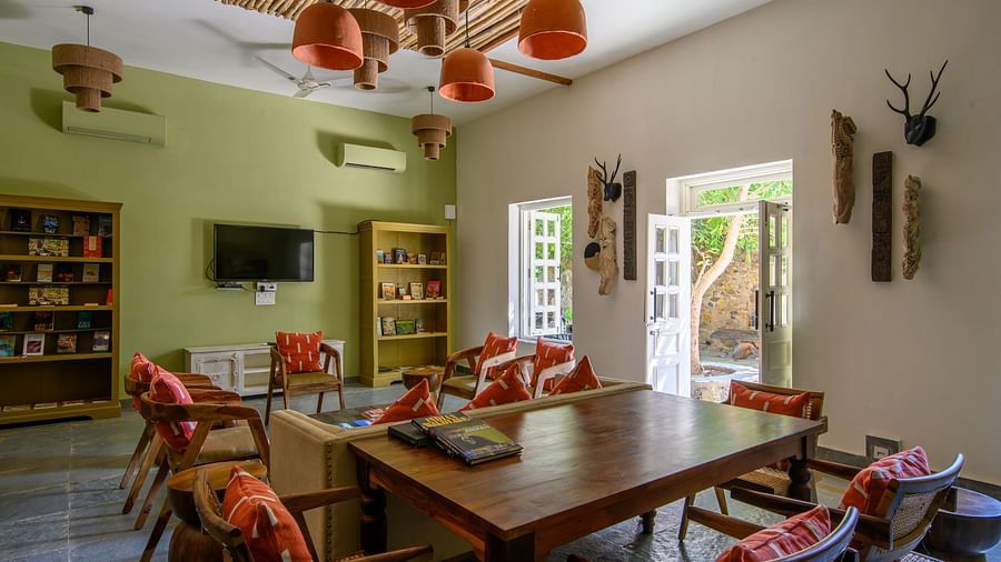 An image of a room with sofa set, center table wall hangings and paintings with minimal decorations - Utsav Camp Sariska