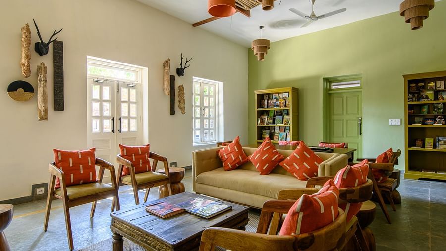 An image of a room with sofa set, center table wall hangings and paintings with minimal decorations - Utsav Camp Sariska
