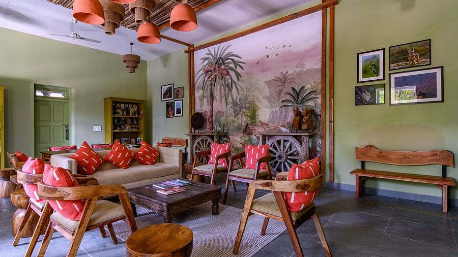 An image of a room with sofa set, center table wall hangings and paintings with minimal decorations - Utsav Camp Sariska
