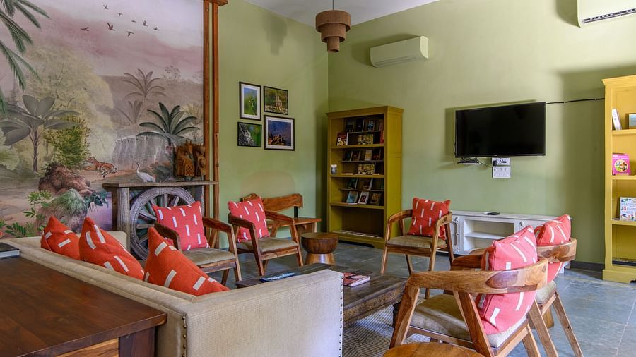 An image of a room with sofa set, center table wall hangings and paintings with minimal decorations - Utsav Camp Sariska