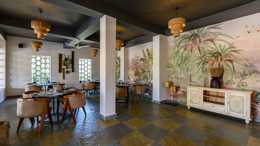 An image of a restaurant with with seating arrangement and buffet with minimal decoration - Utsav Camp Sariska