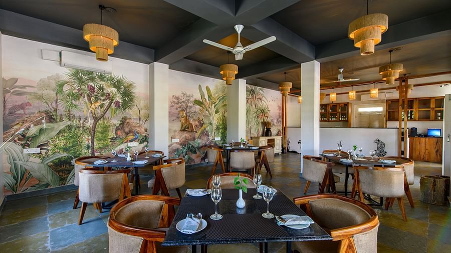 An image of a restaurant with with seating arrangement and buffet with minimal decoration - Utsav Camp Sariska