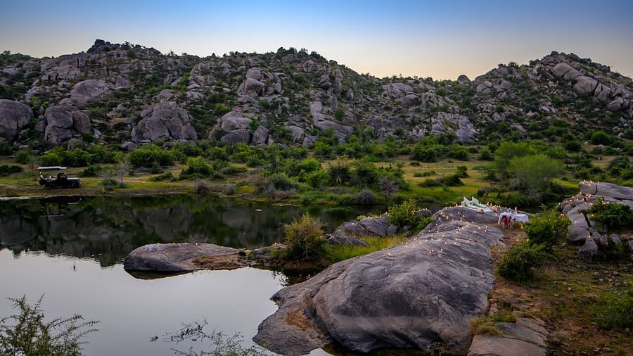 An image of a lake with the backdrop of a rocky mountain - Utsav Camp Sariska