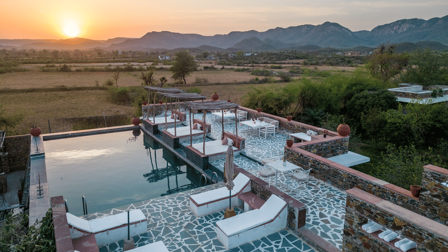 An aerial view image of a seating arrangement near the swimming pool in the open - Utsav Camp Sariska