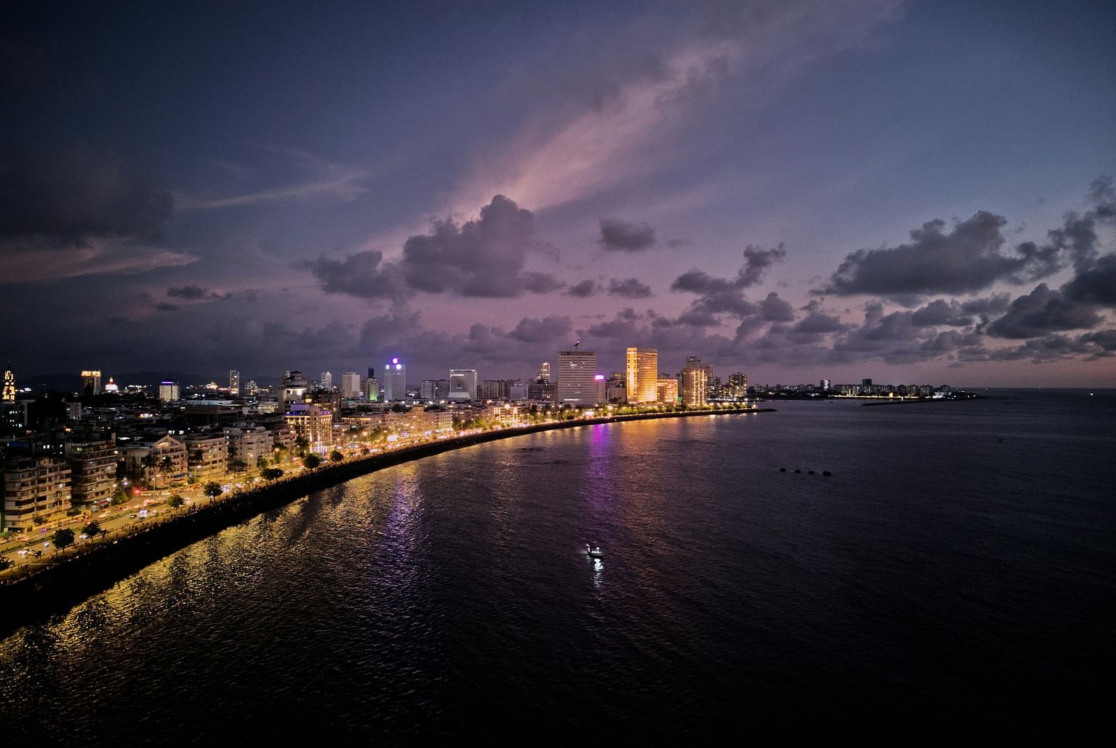 An overview of Marine Drive in the night with the lights on during twilight.
