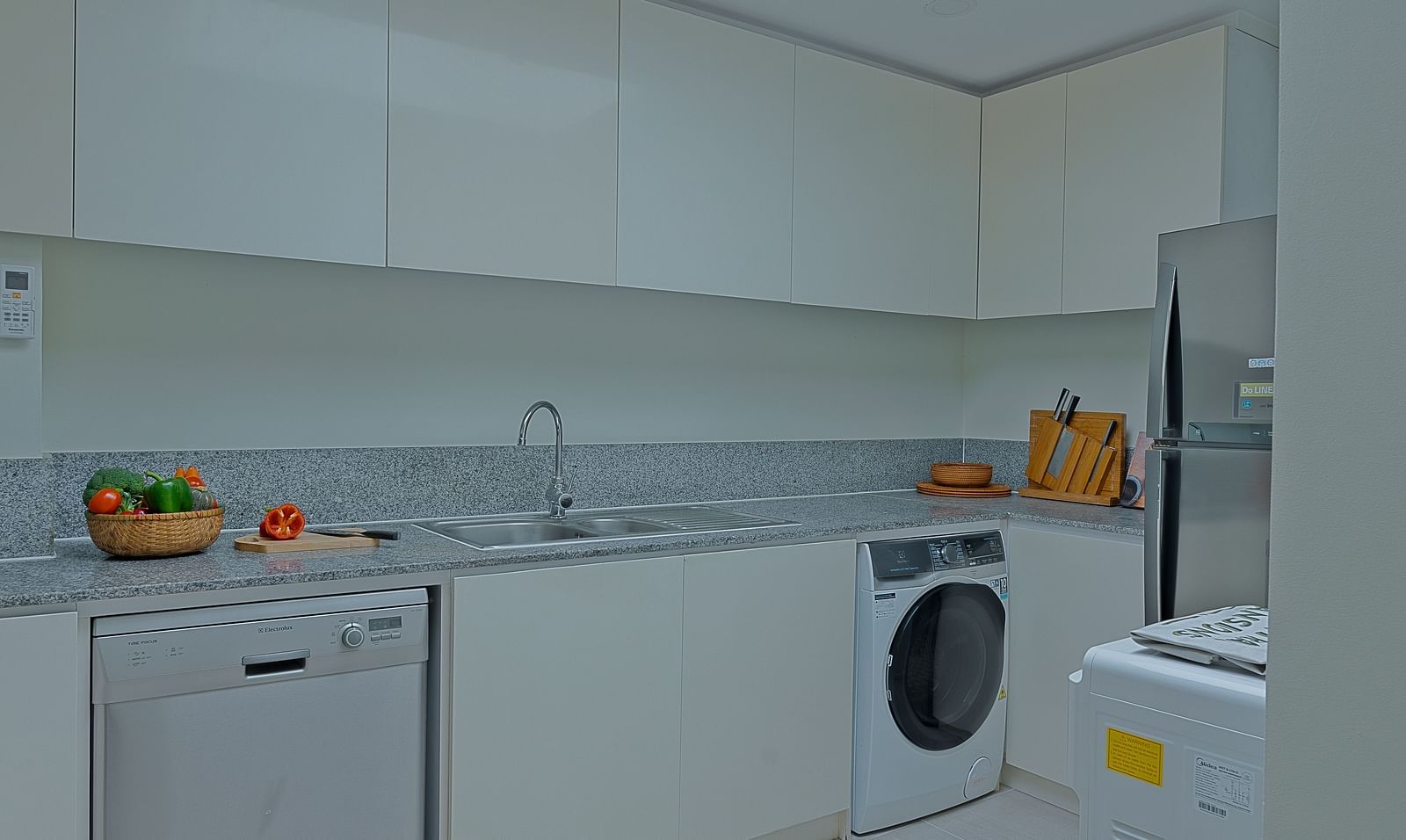 A kitchen with white cabinets, a sink, and a washing machine | Penthouse | Central Mansions, Phnom Penh