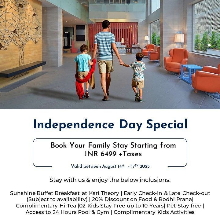 Creative family lifestyle photography of a father walking hand-in-hand with two young children through the hotel lobby, with one child carrying a red cape, showcasing the Independence Day Special family-friendly atmosphere at Radisson Bengaluru.
