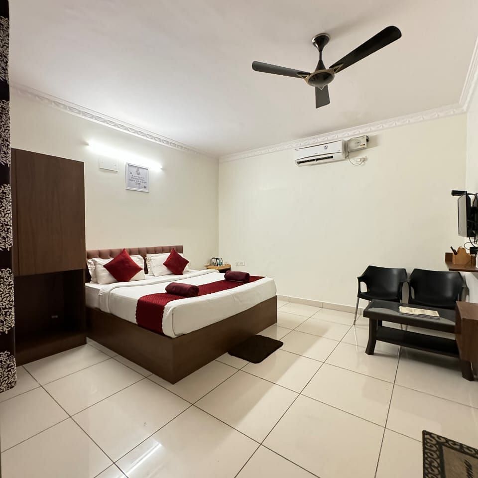 A full view of the bedroom with a large bed and wooden furniture | Vistar Resort, Bengaluru