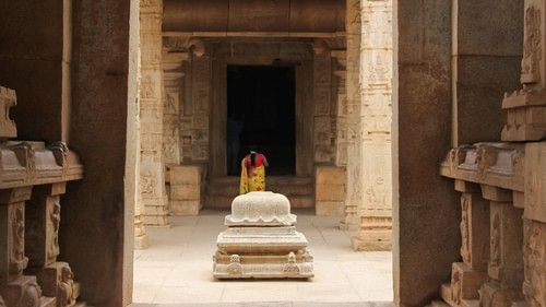 interior view of a temple in which a woman is praying in the distance