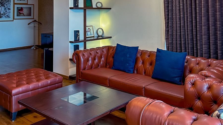 Warm and inviting lounge area with sofa seating and chandelier lighting at Aranya Retreat, Mashobra