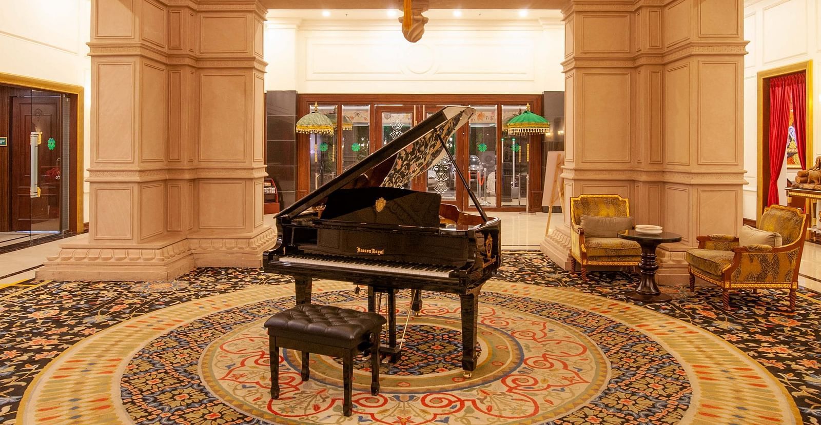 a piano kept in the centre of a room and a chandelier hanging from atop - Mayfair Lake Resort, Raipur 