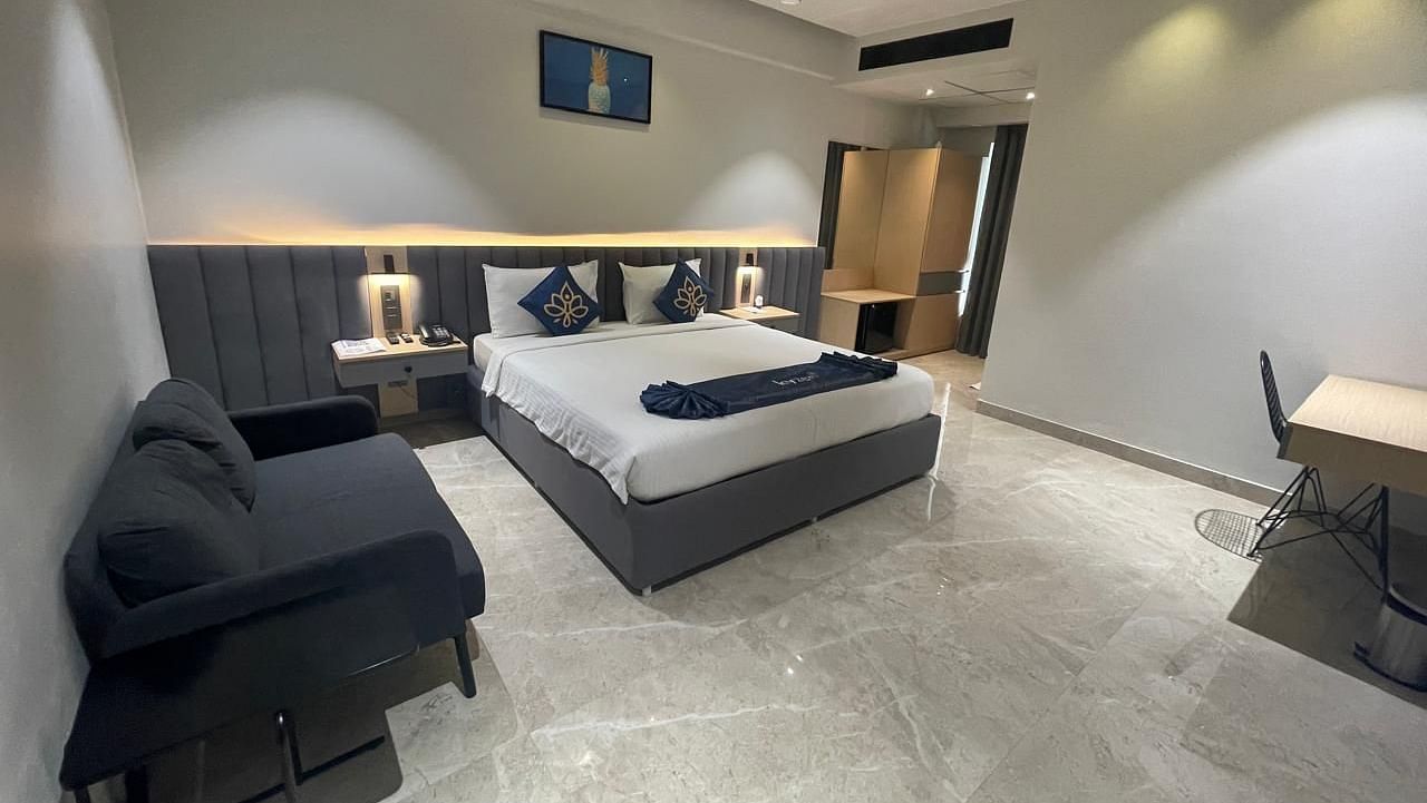 Suite with stylish furniture, including a sofa and writing desk at Hotel Kyzen HiTech City – Your Zenly Stayty.