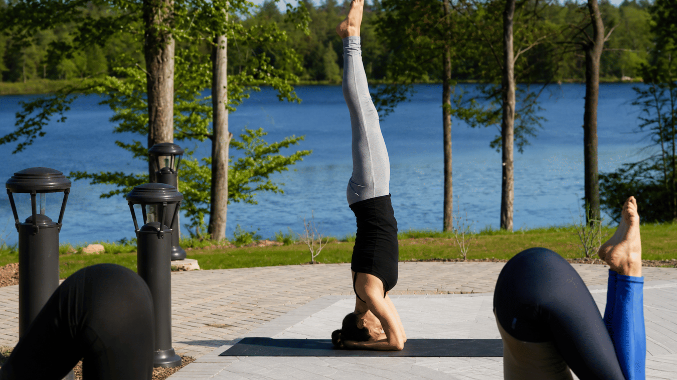 A group of people practicing yoga on a sunny patio at YO1 Longevity and Health Resorts
