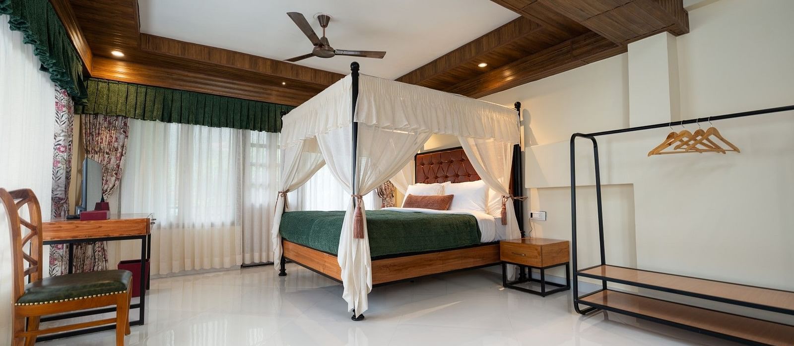  The Premium Suite with a Balcony boasts large windows, a spacious bed with ample lighting, and wooden furniture
