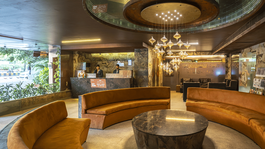 Infiniti Hotel, Indore's lobby with a circular seating arrangement, marble floors, and a central chandelier hanging from the ceiling.